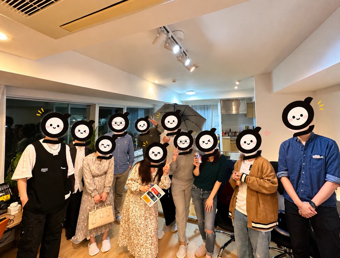 オフィスに集まったGlotureのメンバー11人の集合写真。あたたかい照明の室内で、全員の顔をGlotureの「g」ロゴのマスコット(黒いgの中に、小さな目と笑顔、ほんのりピンクの頬の白い顔)で隠しています。